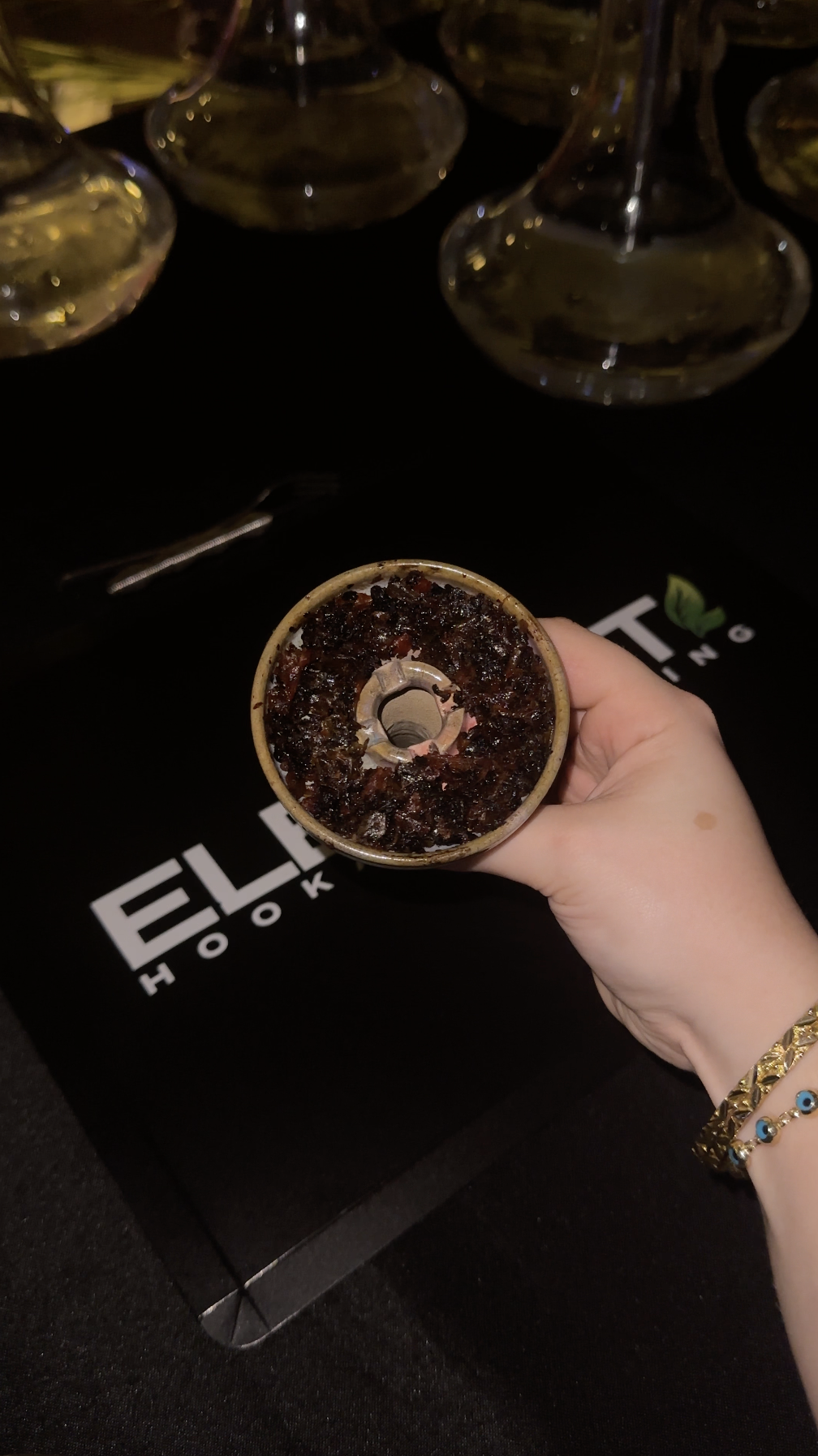Packed hookah bowl held over an Element table.