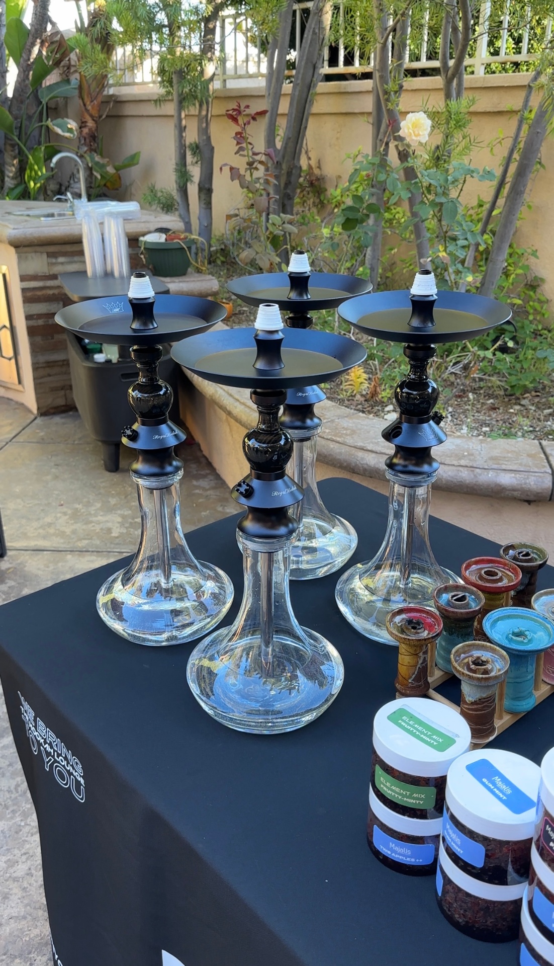 Element hookah setup outdoors with flavored tobacco jars.
